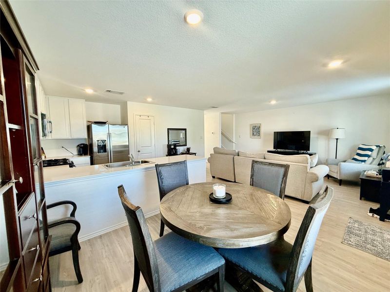 Dining room with light wood-type flooring and recessed lighting