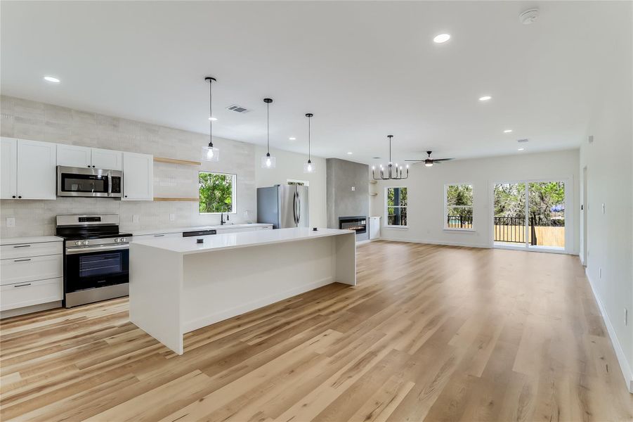 Kitchen featuring light wood-style flooring, recessed lighting, light countertops, and appliances with stainless steel finishes