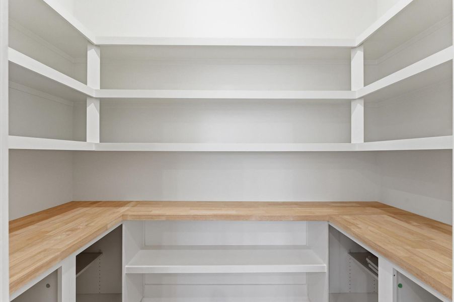 Walk-in pantry has a functional butcher block counter.