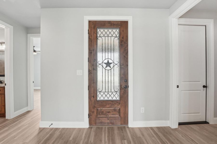 Entryway with light wood finished floors and baseboards