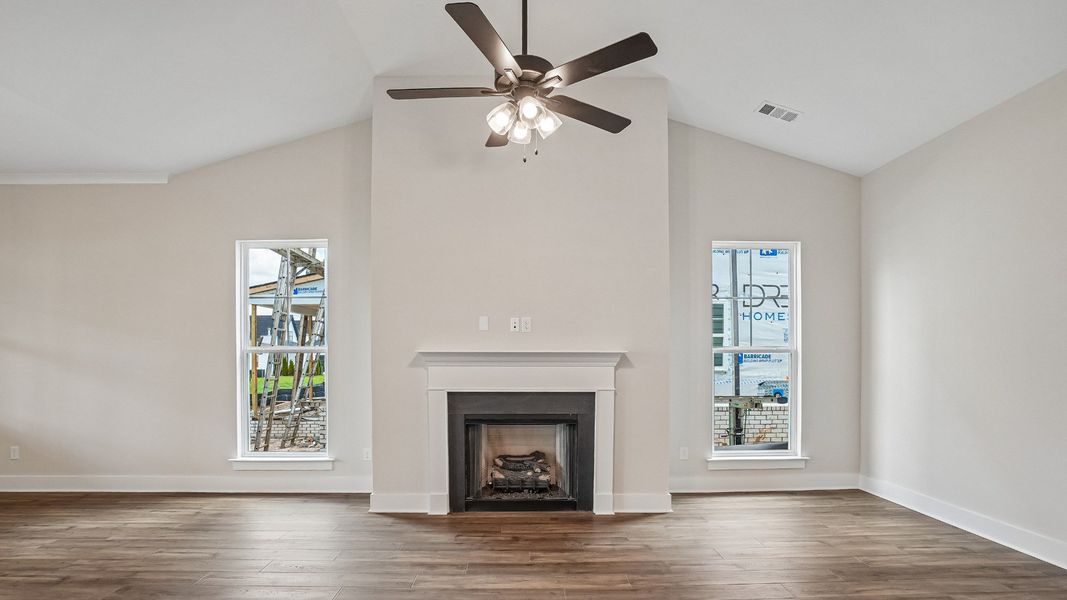 Open Concept layout living room with fireplace and vaulted ceiling
