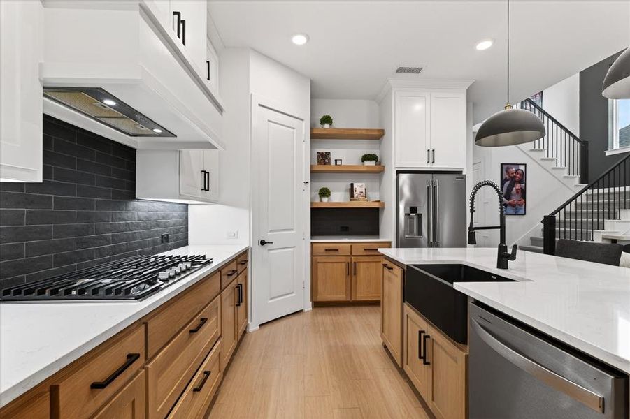 Kitchen featuring appliances with stainless steel finishes, light stone countertops, hanging light fixtures, open shelves, and recessed lighting Kitchen featuring appliances with stainless steel finishes, light stone countertops, hanging light fixtures, open shelves, and recessed lighting