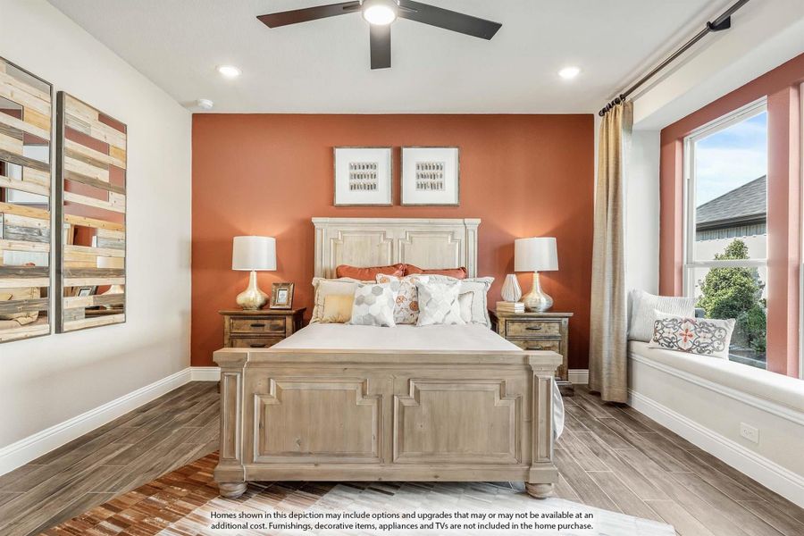 Bedroom with wood bed frame, orange accent wall, ceiling fan, and window seat Bedroom with wood bed frame, orange accent wall, ceiling fan, and window seat