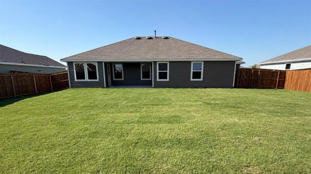 Expansive green lawn with a full wooden privacy fence