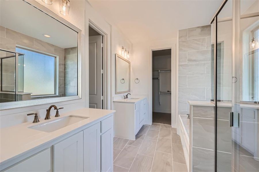 Bathroom with double vanity, plus walk in shower, and tile patterned flooring