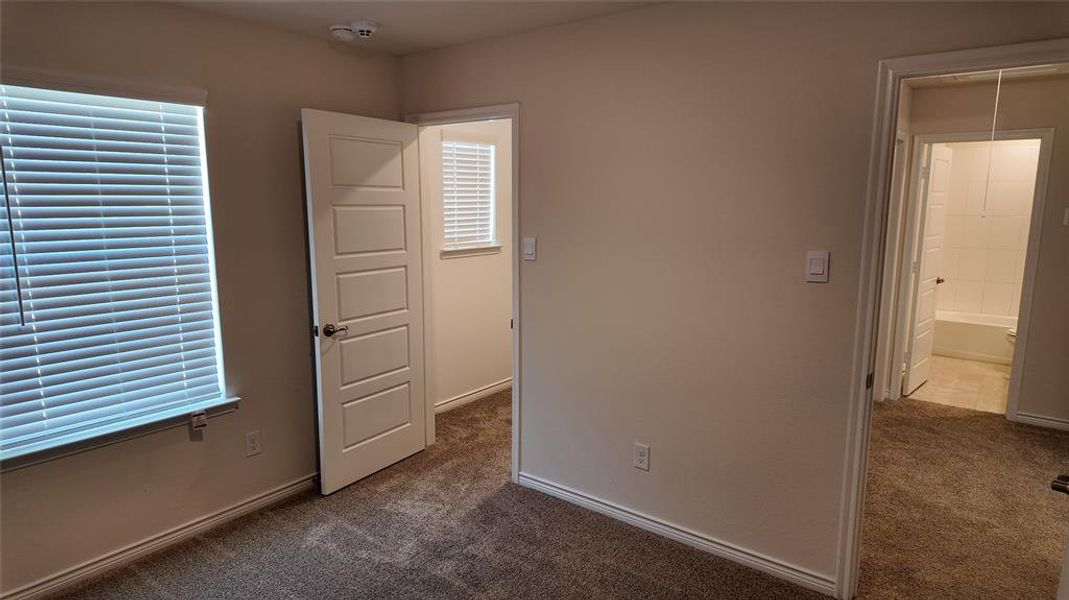 Unfurnished bedroom with dark carpet