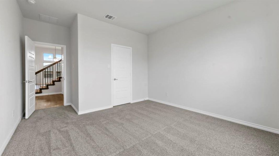 Spacious room featuring light gray carpeting and white walls