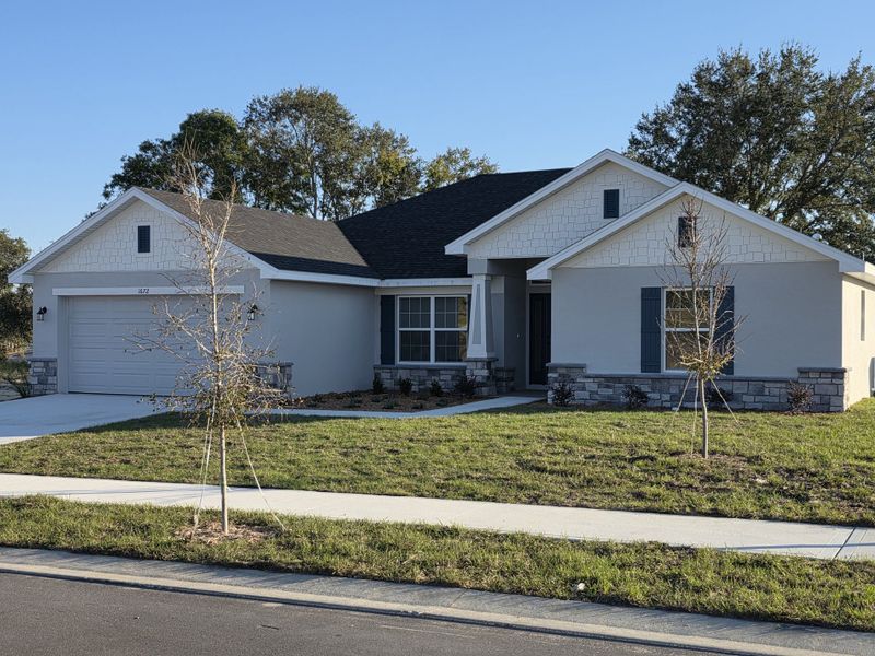 Front exterior of a new home in Arbor Park, Leesburg, FL, highlighting curb appeal (Image 1).