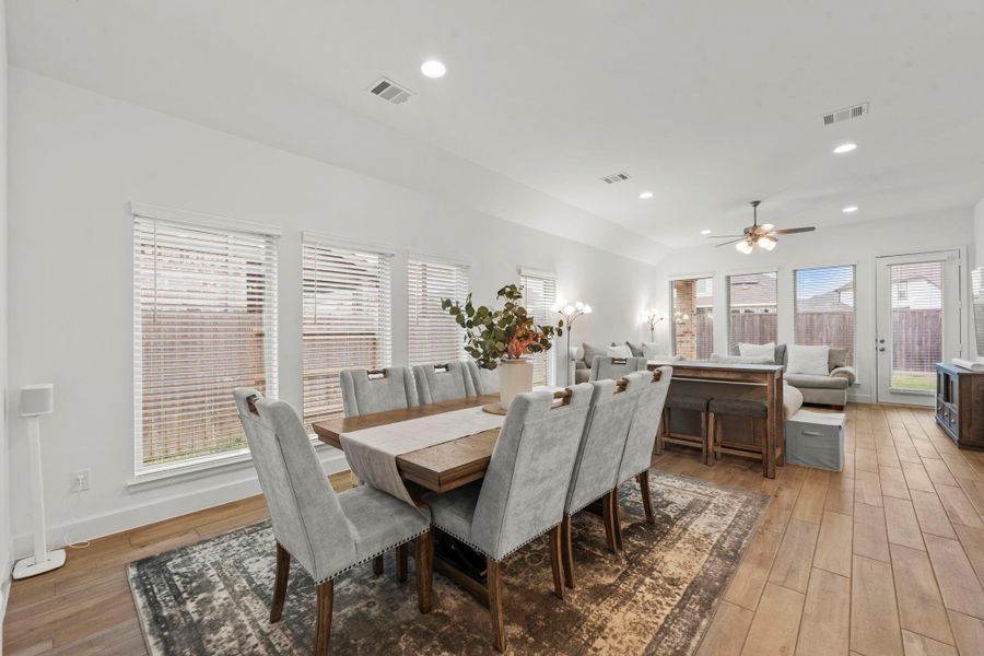Designed for everyday living and special occasions alike, this open dining space transitions effortlessly from relaxed family meals to elegant entertaining. It features wood-look tile flooring, three sunny windows with 2” blinds, a sloped ceiling, and clean recessed lighting.