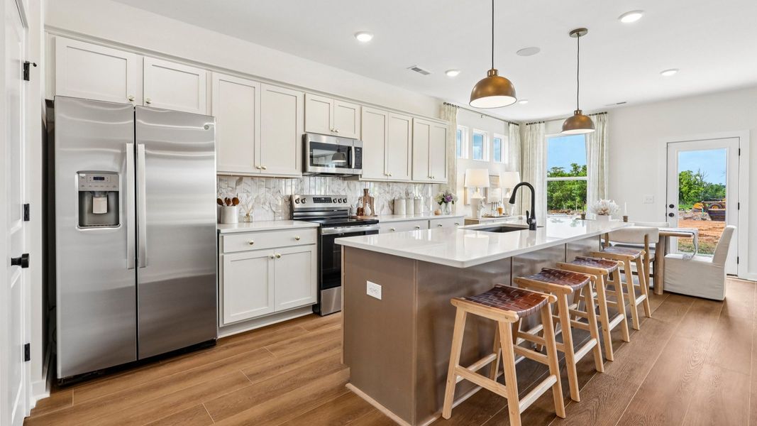 Kitchen with tile backsplash, pendant lighting, and quartz countertops Kitchen with tile backsplash, pendant lighting, and quartz countertops