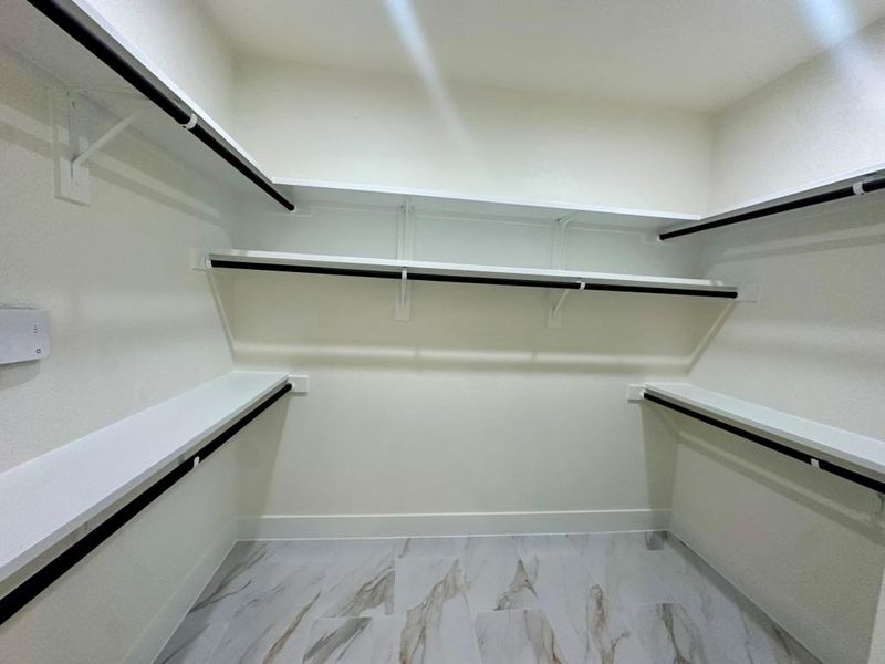 Spacious closet featuring light marble finish floors