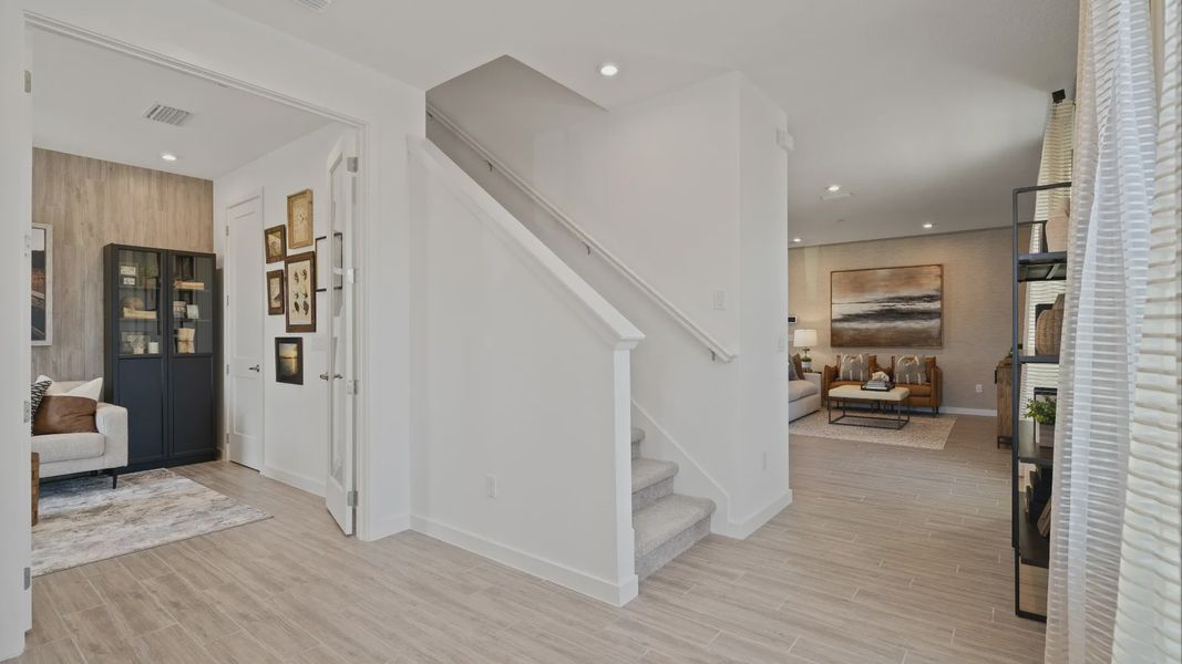 Entry view of flex room, stairs and family room in a DRB Home Clementine model at the Trinity Place community.