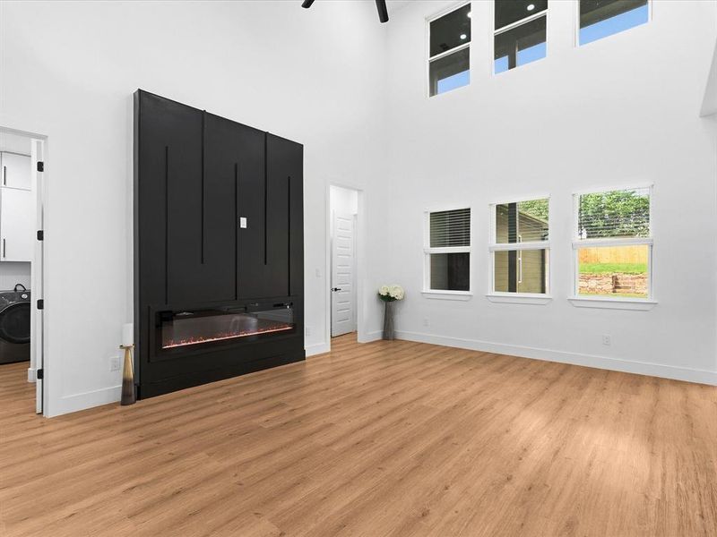Great room featuring a prominent black accent wall with an integrated electric fireplace