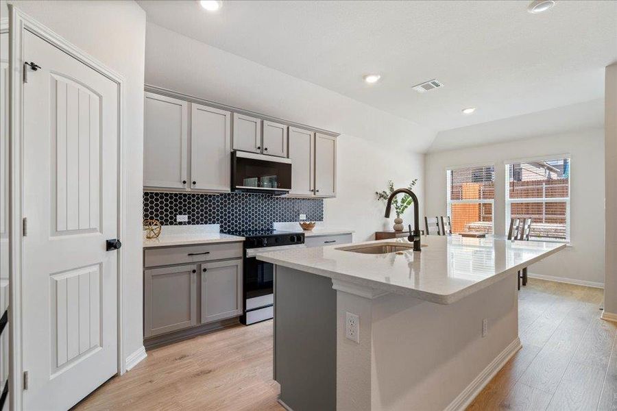 Kitchen featuring visible vents, a sink, stainless steel appliances, and gray cabinets