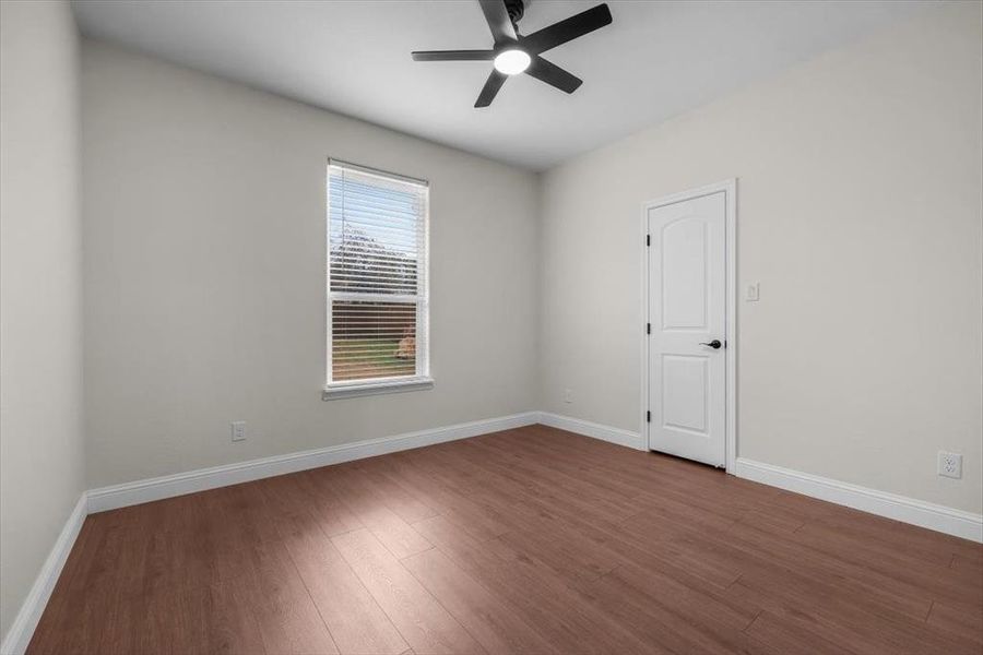 Empty room featuring hardwood / wood-style flooring and ceiling fan