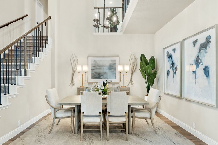 Formal dining room with two-story ceiling, six-chair table, chandelier, and staircase nearby Formal dining room with two-story ceiling, six-chair table, chandelier, and staircase nearby