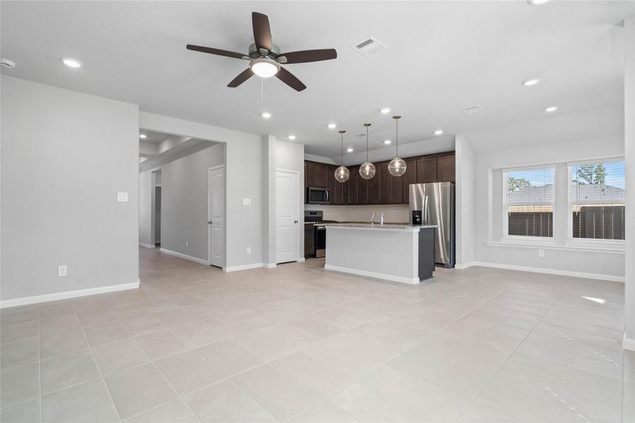This expansive view from the back of the house showcases a seamless, open-concept layout that creates a warm and inviting space.