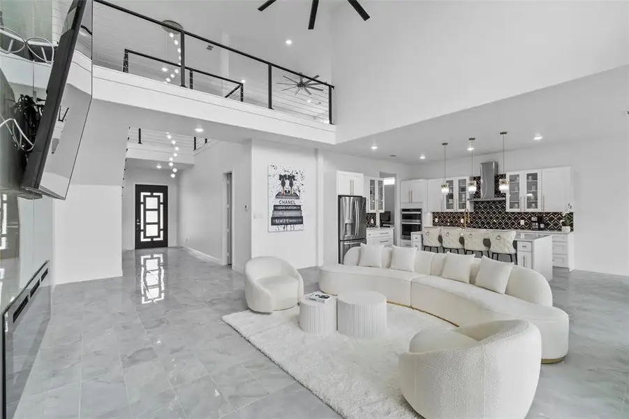 Open-concept living area with high ceilings and light-toned tile flooring