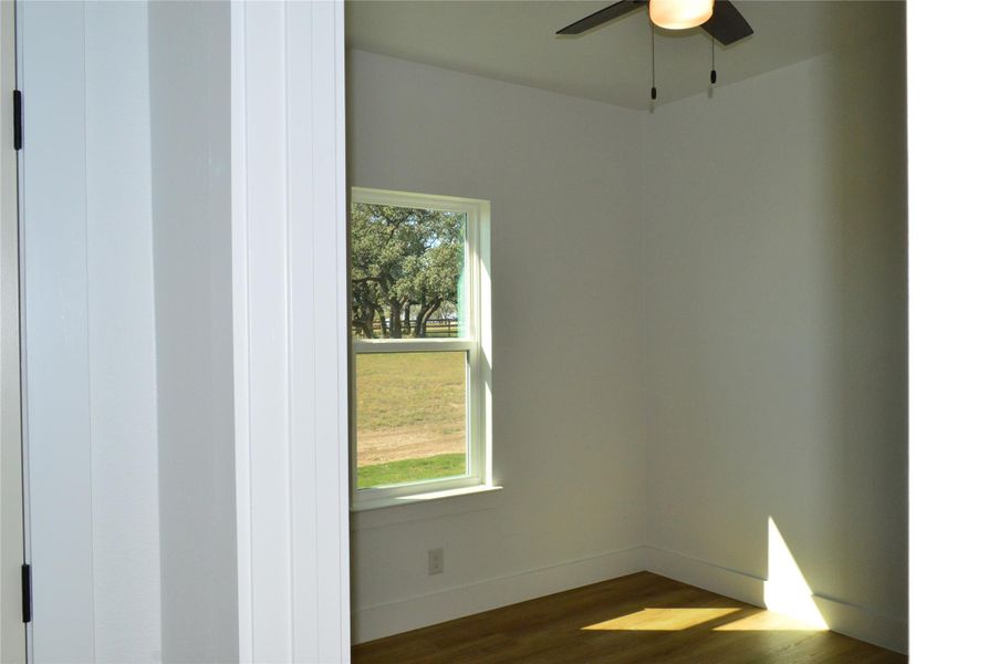 Unfurnished room with dark wood-type flooring and baseboards Unfurnished room with dark wood-type flooring and baseboards