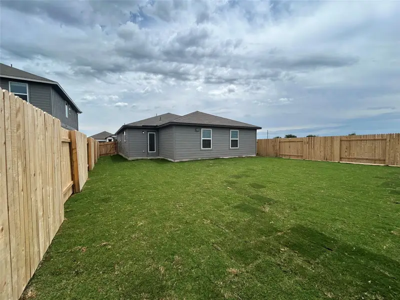 Back of house with a fenced backyard