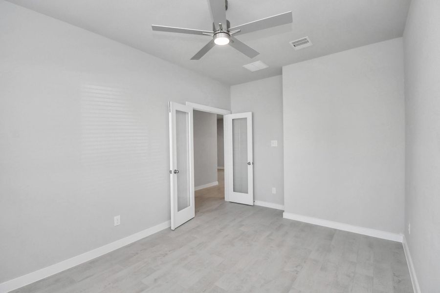 Experience the perfect blend of sophistication and warmth in this home office, boasting elegant wood-look tile flooring and flooded with natural light from expansive windows and French doors. Sample photo of completed home with similar floor plan. Actual colors and selections may vary. Experience the perfect blend of sophistication and warmth in this home office, boasting elegant wood-look tile flooring and flooded with natural light from expansive windows and French doors. Sample photo of completed home with similar floor plan. Actual colors and selections may vary.