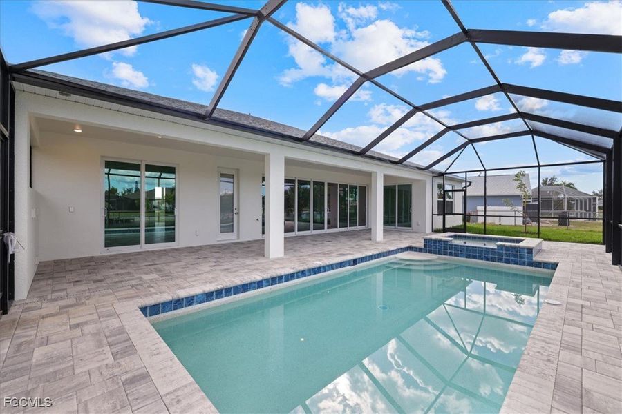 View of swimming pool featuring a sunroom, glass enclosure, a patio area, and a pool with connected hot tub