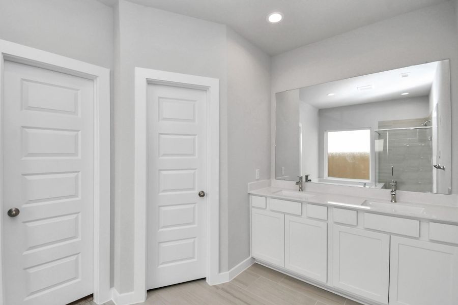 Escape to a spa-like oasis in this primary bathroom. Enjoy a walk-in shower with tile surround, a separate garden tub with custom detailing, and an elegant vanity featuring light countertops, modern hardware, and beautiful recessed lights. Experience luxury and relaxation in every detail. Escape to a spa-like oasis in this primary bathroom. Enjoy a walk-in shower with tile surround, a separate garden tub with custom detailing, and an elegant vanity featuring light countertops, modern hardware, and beautiful recessed lights. Experience luxury and relaxation in every detail.