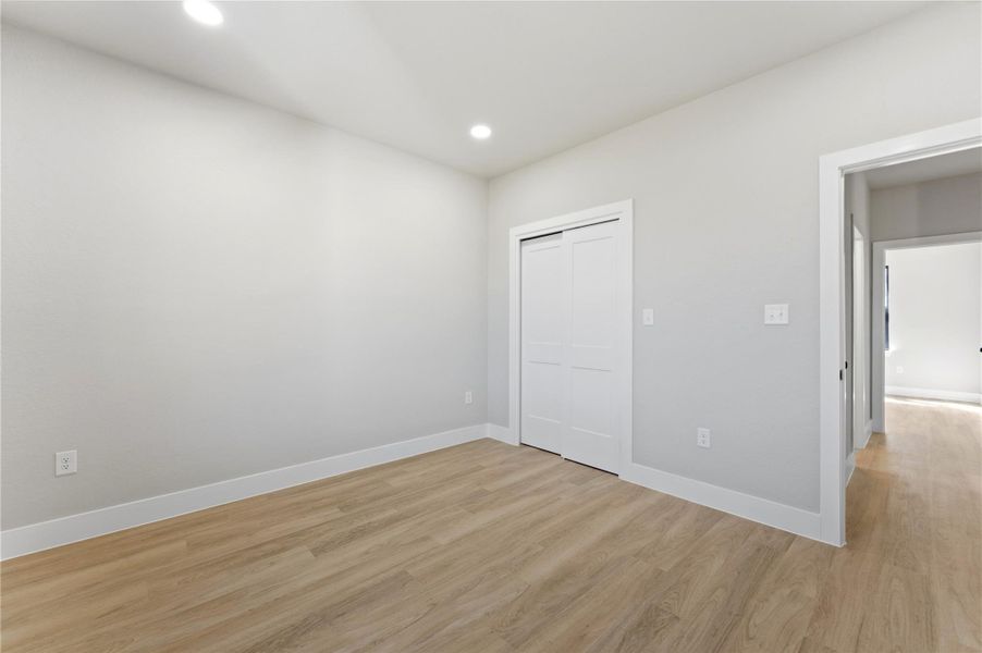 Unfurnished bedroom featuring light wood-style floors, recessed lighting, and a closet