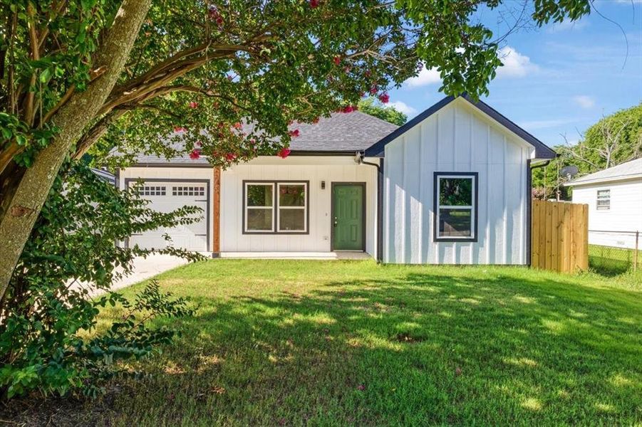 Back of property with a garage and a yard