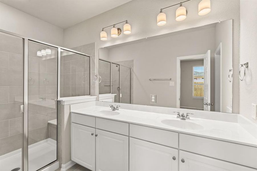 The en-suite bathroom offers a spa-like atmosphere with its elegant design, high end finishes, and tasteful lighting, creating a retreat within your own home.