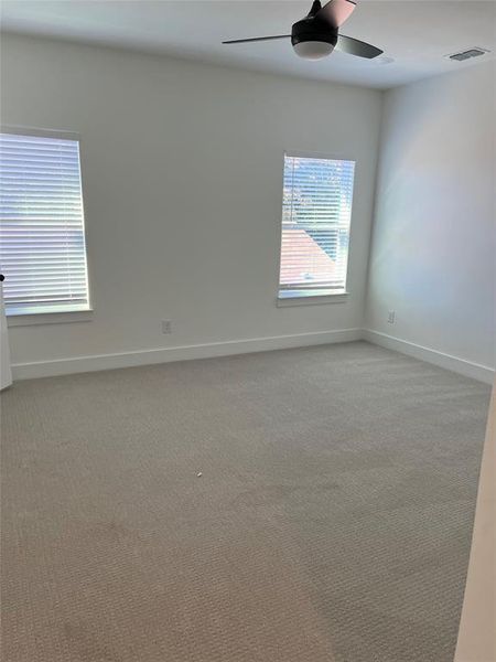 Carpeted empty room with ceiling fan