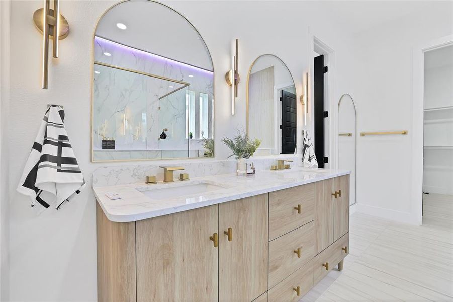 Bathroom featuring a marble finish shower, double vanity, and recessed lighting