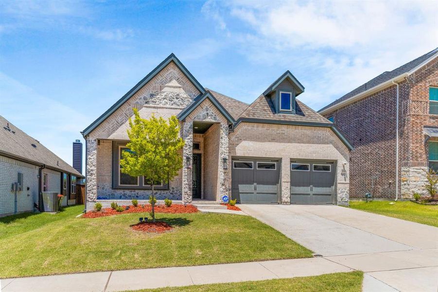 French country home with brick siding, driveway, a front lawn, and central AC unit French country home with brick siding, driveway, a front lawn, and central AC unit