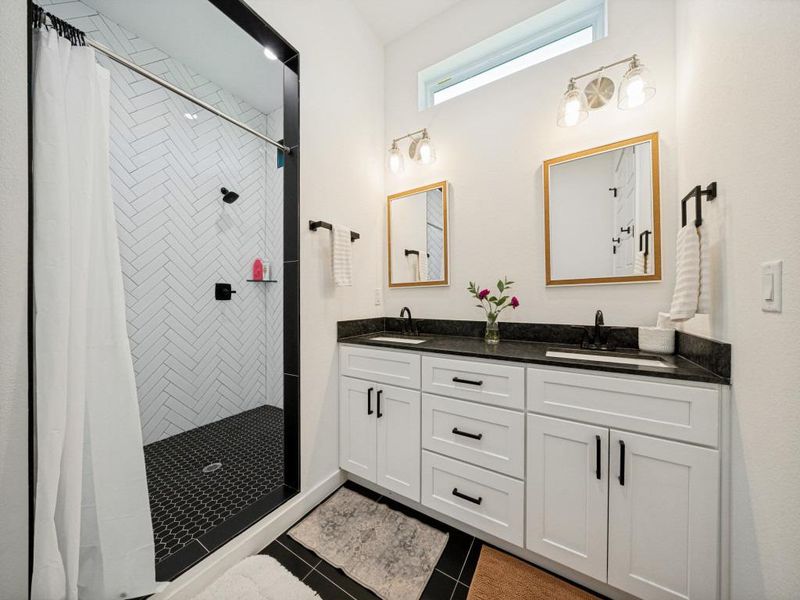A well-appointed bathroom features a spacious shower with striking tile work and a dual vanity with ample storage. A well-appointed bathroom features a spacious shower with striking tile work and a dual vanity with ample storage.