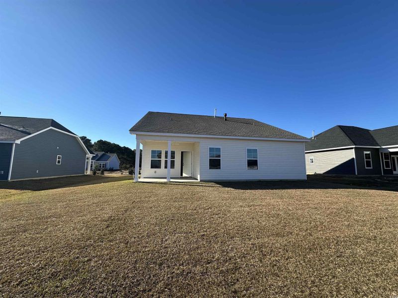 Back of house featuring a patio area and a lawn