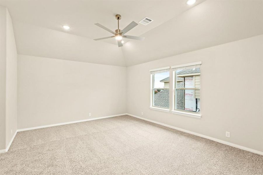 Empty room featuring vaulted ceiling, carpet floors, recessed lighting, and a ceiling fan