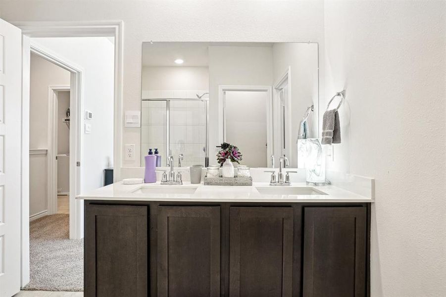 Full bathroom with a shower stall, double vanity, and a walk in closet Full bathroom with a shower stall, double vanity, and a walk in closet