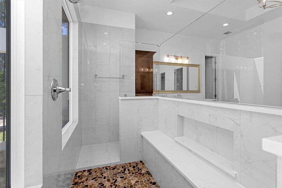 The oversized walk-in shower blends luxury and function with a river rock floor, tile surround, built-in bench, and spa-style fixtures—all bathed in natural light. The oversized walk-in shower blends luxury and function with a river rock floor, tile surround, built-in bench, and spa-style fixtures—all bathed in natural light.