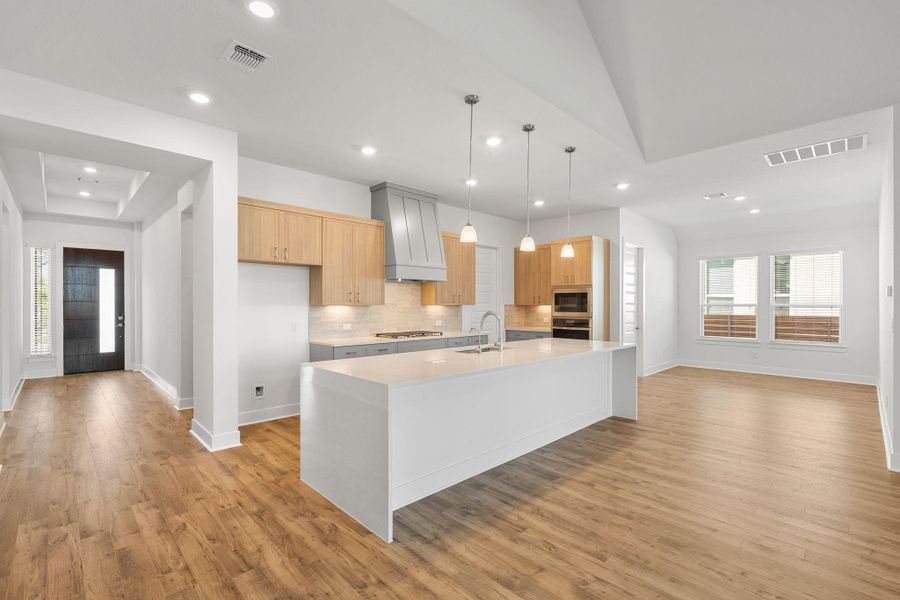 An open concept design seamlessly connects a gourmet kitchen to a spacious living area, ideal for entertaining.