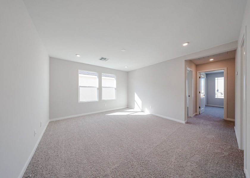 A room with a carpet and a window.