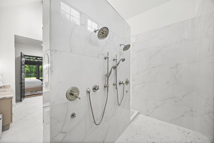 A stunning marble walk-in shower equipped with dual rain heads, body sprays, and handheld fixtures, creating a resort-level retreat at home A stunning marble walk-in shower equipped with dual rain heads, body sprays, and handheld fixtures, creating a resort-level retreat at home