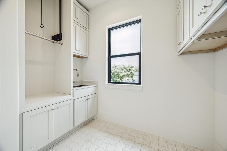 Laundry with utility sink, built-ins and pull down rod.