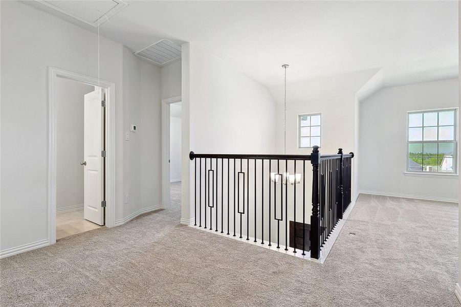 Hallway featuring light carpet and plenty of natural light