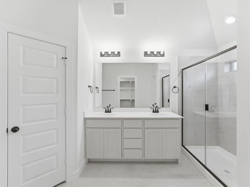 Bright bathroom featuring a dual vanity with white cabinetry, white countertops, and black fixtures Bright bathroom featuring a dual vanity with white cabinetry, white countertops, and black fixtures