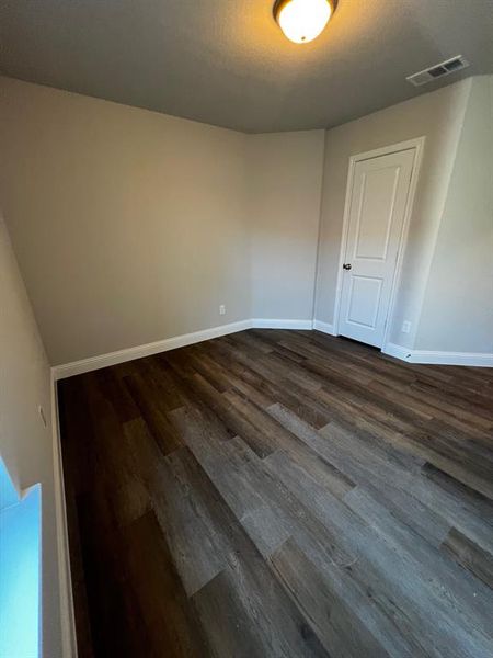 Empty room with dark wood-type flooring