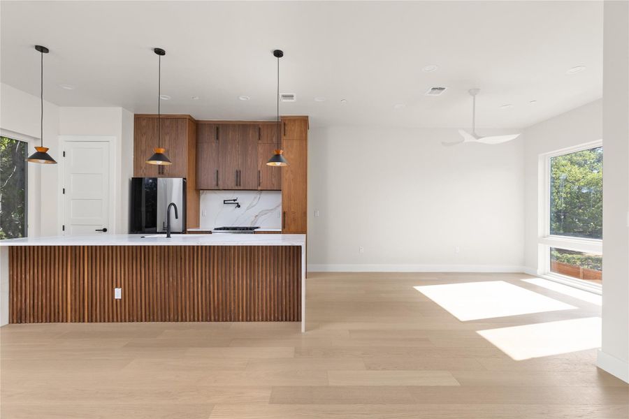 Rich wood cabinetry contrasts beautifully with clean white walls and light hardwood flooring.