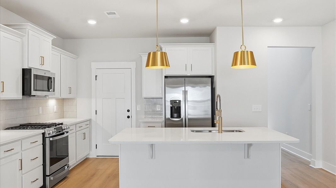 Highly skilled craftsmanship shines in this modern kitchen with pendant lighting and a central island focal point Highly skilled craftsmanship shines in this modern kitchen with pendant lighting and a central island focal point