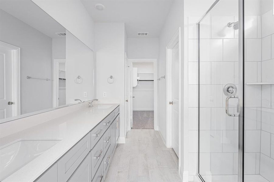 Full bathroom featuring a stall shower, visible vents, and a sink