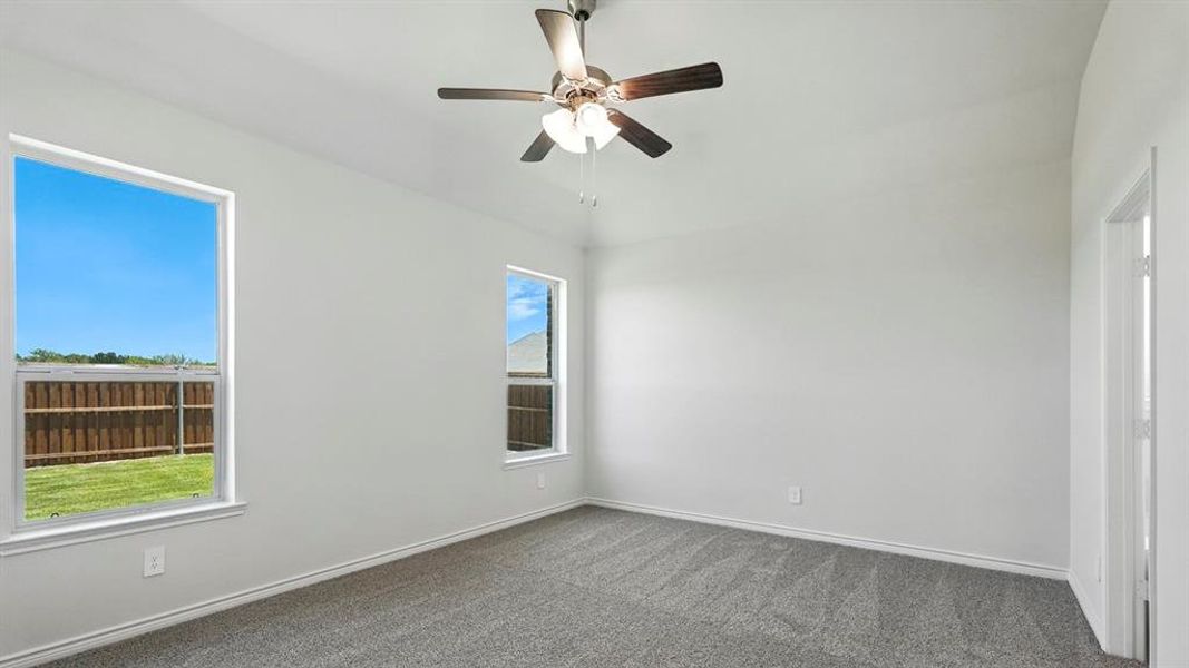 Spacious room featuring vaulted ceilings, light gray carpeting, and two windows Spacious room featuring vaulted ceilings, light gray carpeting, and two windows