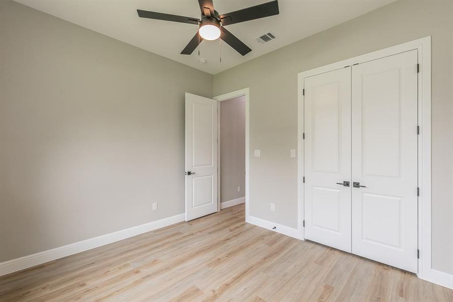 Unfurnished bedroom featuring light wood finished floors, a closet, baseboards, and ceiling fan Unfurnished bedroom featuring light wood finished floors, a closet, baseboards, and ceiling fan